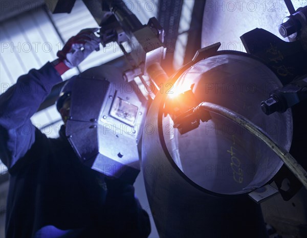 Caucasian worker working on steel pipe in factory