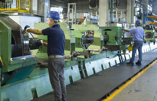 Caucasian workers working in steel factory