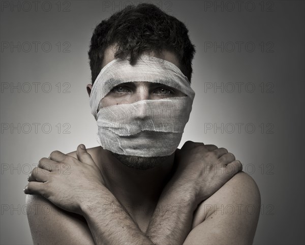 Man with bandages on his face