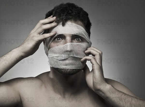 Man with bandages on his face