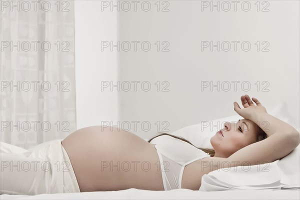 Pregnant woman laying in bed