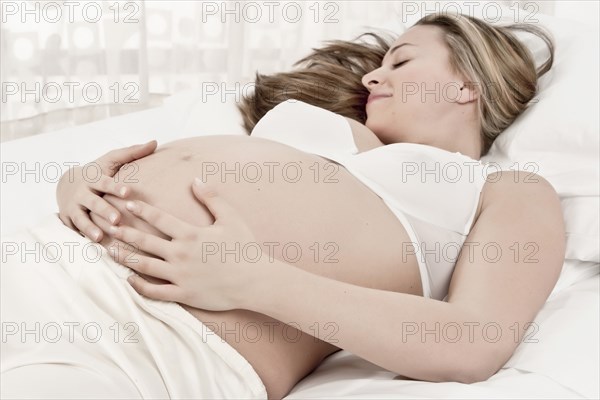 Pregnant woman laying in bed