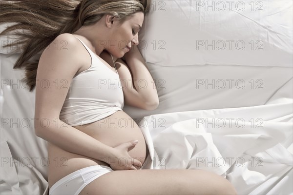 Pregnant woman sleeping in bed