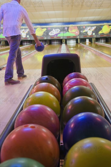 Bowler throwing bowling ball down lane