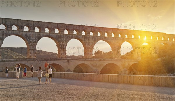 People sightseeing near aqueduct