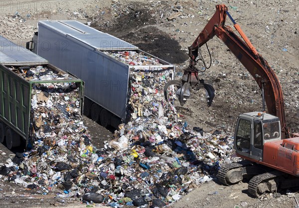 Trucks dumping refuse into landfill
