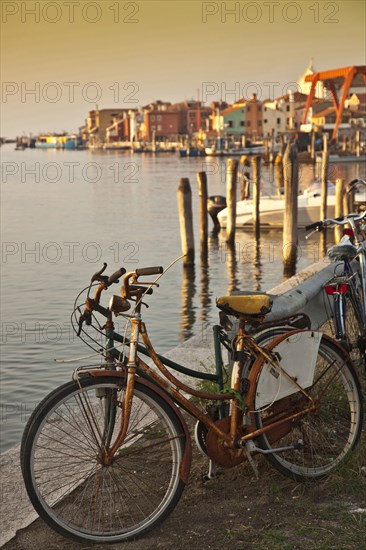 Bicycle parked by urban canal