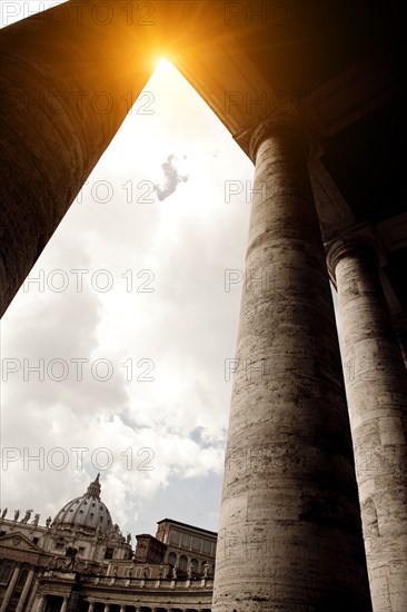 Sun rising over columned buildings