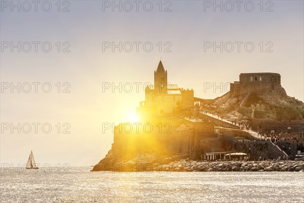 Sun rising over castle on island