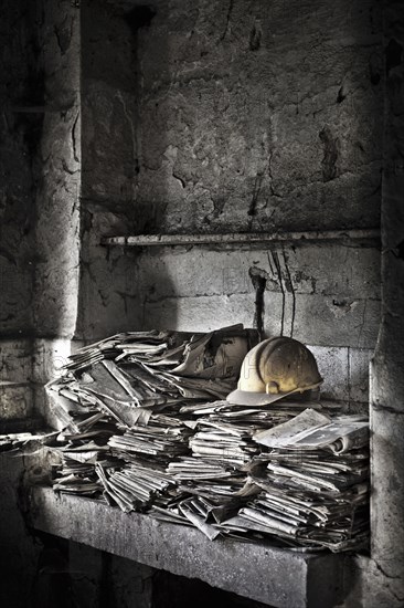 Newspapers and hard hats in factory