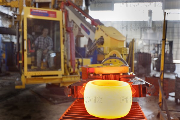 Caucasian worker operating steel melting machinery in factory