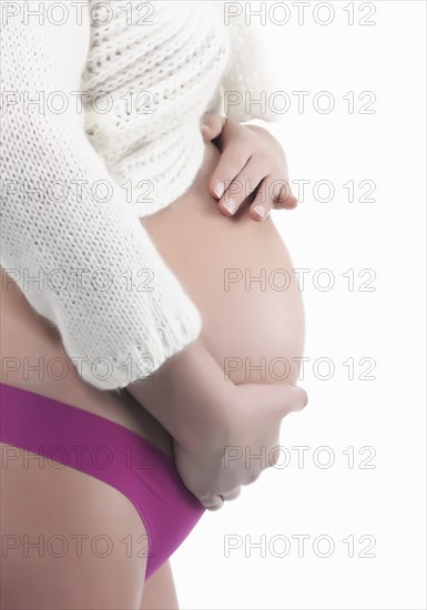 Caucasian woman holding pregnant belly