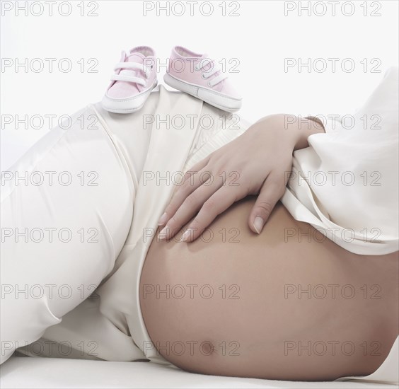 Caucasian woman holding pregnant belly