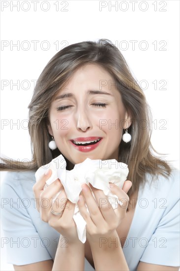 Woman sneezing into tissues