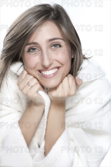 Smiling woman wrapped in bathrobe