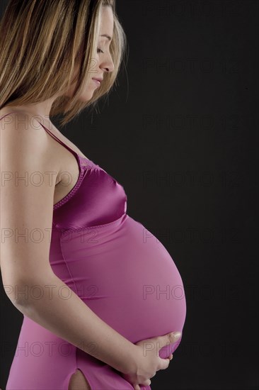 Pregnant Caucasian woman holding her belly