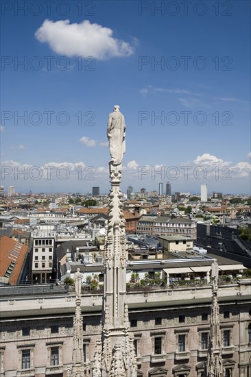 Statue overlooking Milan cityscape