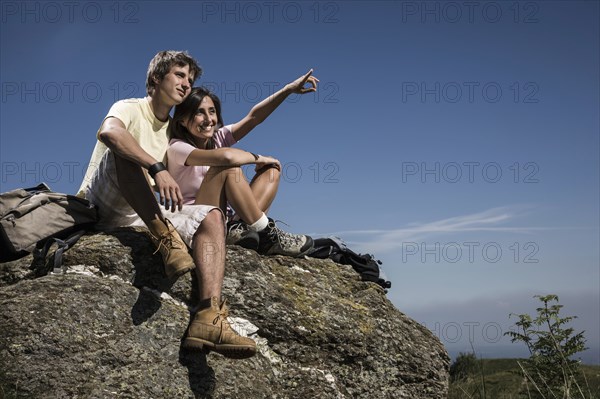 Smiling couple sitting on rock