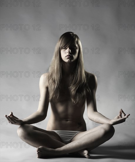 Topless Caucasian woman meditating