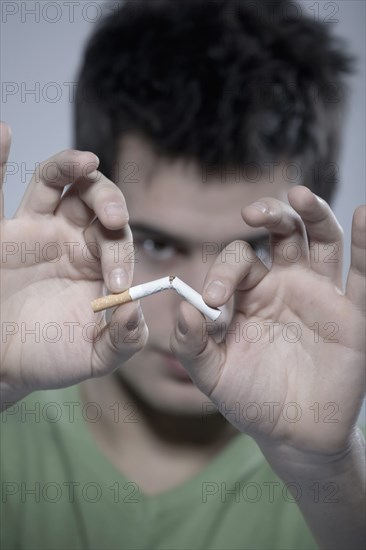 Caucasian man snapping cigarette