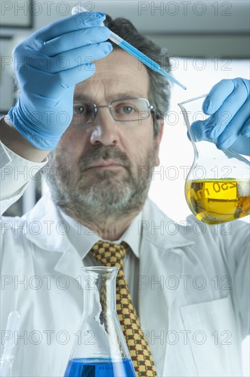 Caucasian scientist mixing liquid in laboratory