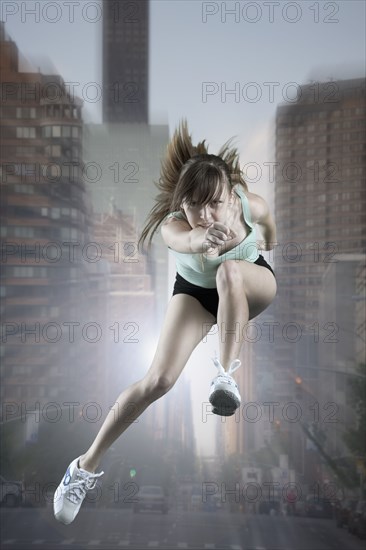 Caucasian woman running and jumping in city