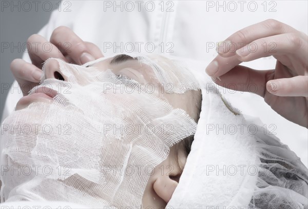 Caucasian woman receiving facial beauty treatment