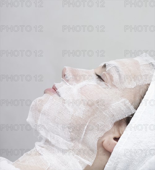 Caucasian woman receiving facial beauty treatment