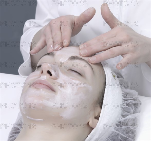 Caucasian woman receiving facial beauty treatment