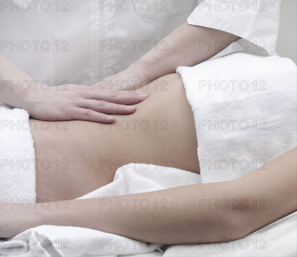 Caucasian woman receiving massage of midsection