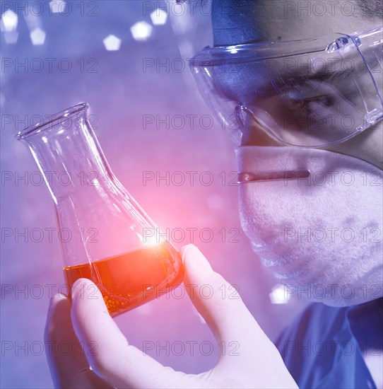 Caucasian scientist examining red liquid