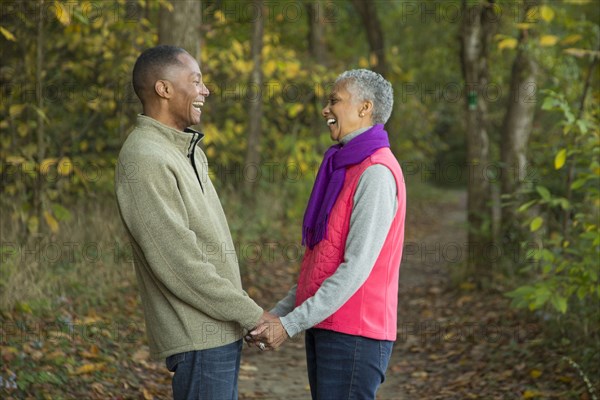 Older couple holding hands in forest