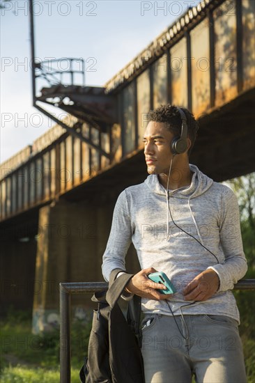 Mixed Race man with backpack listening to headphones