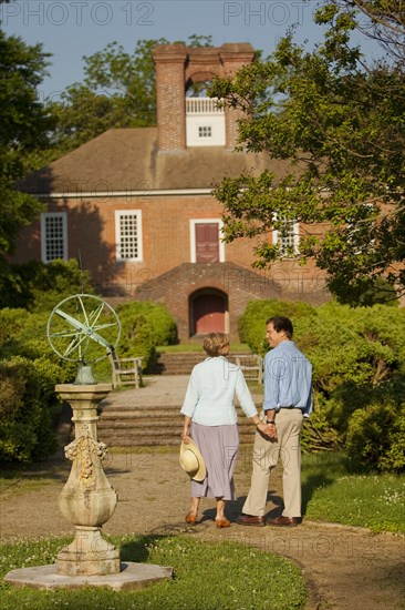 Couple holding hands in garden near house