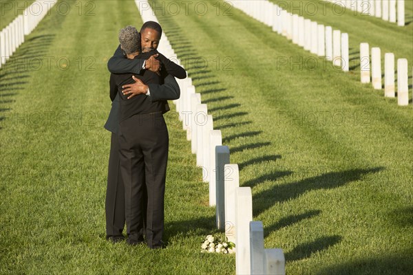 Black couple hugging at military cemetery