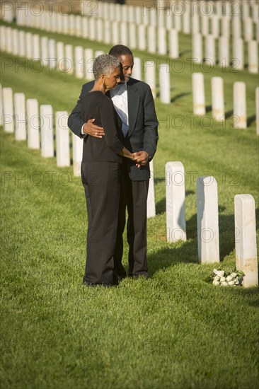 Black couple hugging in military cemetery
