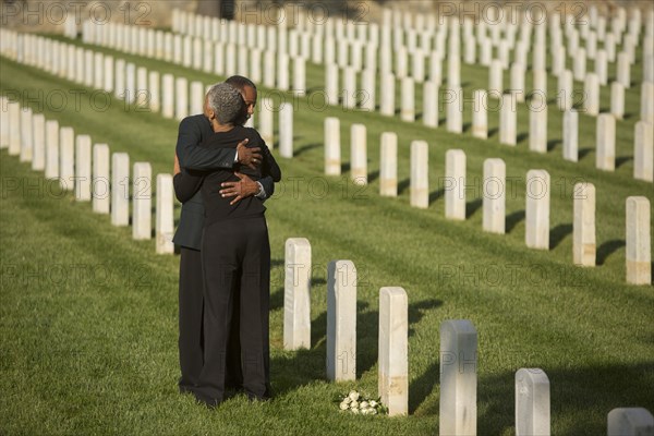 Black couple hugging in military cemetery