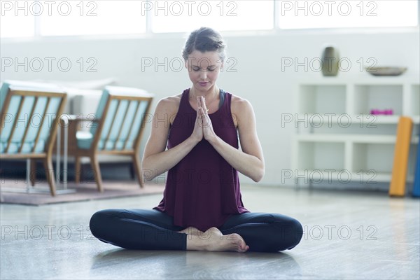 Caucasian woman sitting on floor meditating