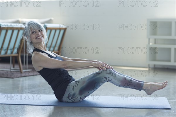 Woman doing yoga balancing on exercise mat