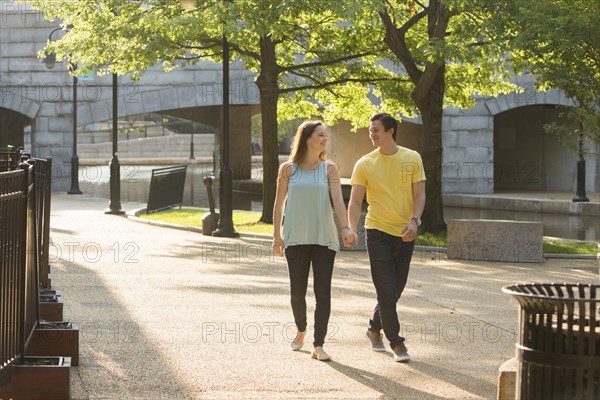 Caucasian couple walking in park