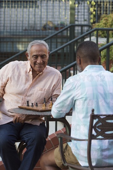 Friends playing chess in garden