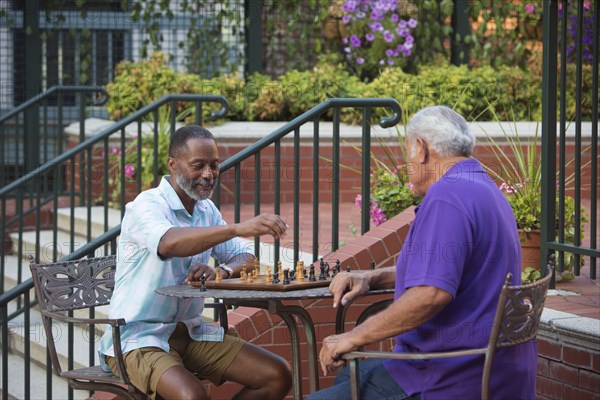 Friends playing chess in garden