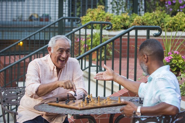 Friends playing chess in garden