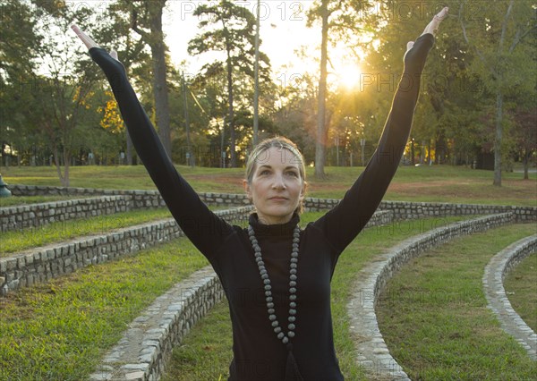 Caucasian woman meditating in park