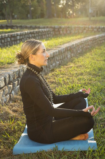 Caucasian woman meditating in park