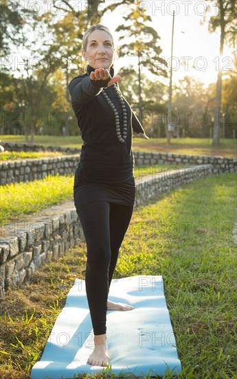 Caucasian woman practicing yoga in park