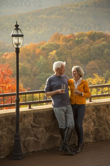 Older Caucasian couple enjoying wine and scenic view