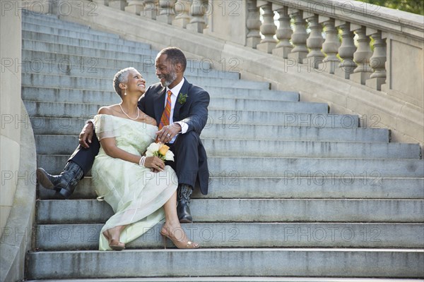 Black couple sitting on stone staircase