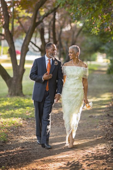 Black couple walking on path in park