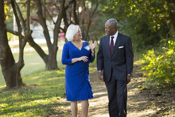 Couple walking and talking on path in park